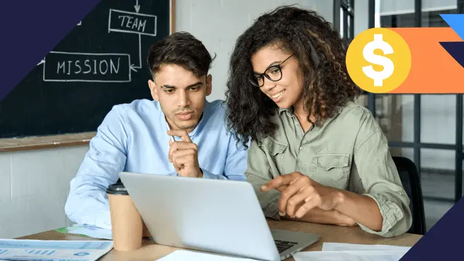 Duas pessoas sentadas à mesa, concentradas em um laptop. Ao fundo, há um quadro-negro com as palavras "TEAM" e "MISSION". Um copo de café está sobre a mesa. Ícone de cifrão no canto superior direito.