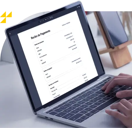 Pessoa digitando em laptop que exibe um "Recibo de Pagamento" na tela. Ao fundo, um suporte com um tablet, desfocado. Logo amarelo de quatro triângulos no canto superior esquerdo da imagem.
